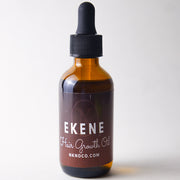 Bottle of "Ekene" Hair OIl with a dropper on a white background