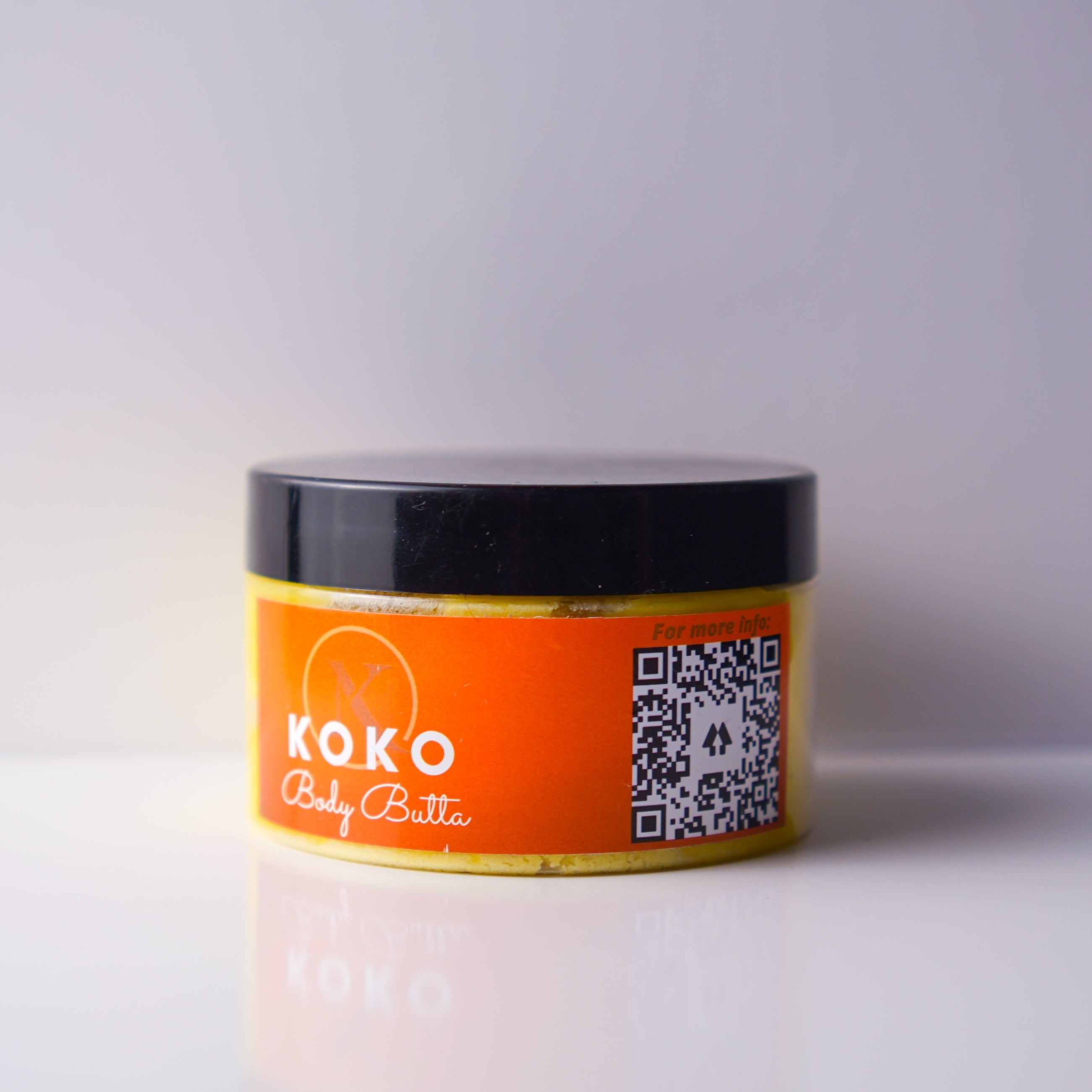 Jar of Koko Body Butter with orange label and black lid on a white background