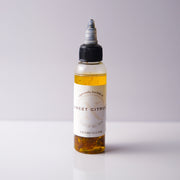 Bottle of 'Sweet Citrus' oil with a white label on a light gray background