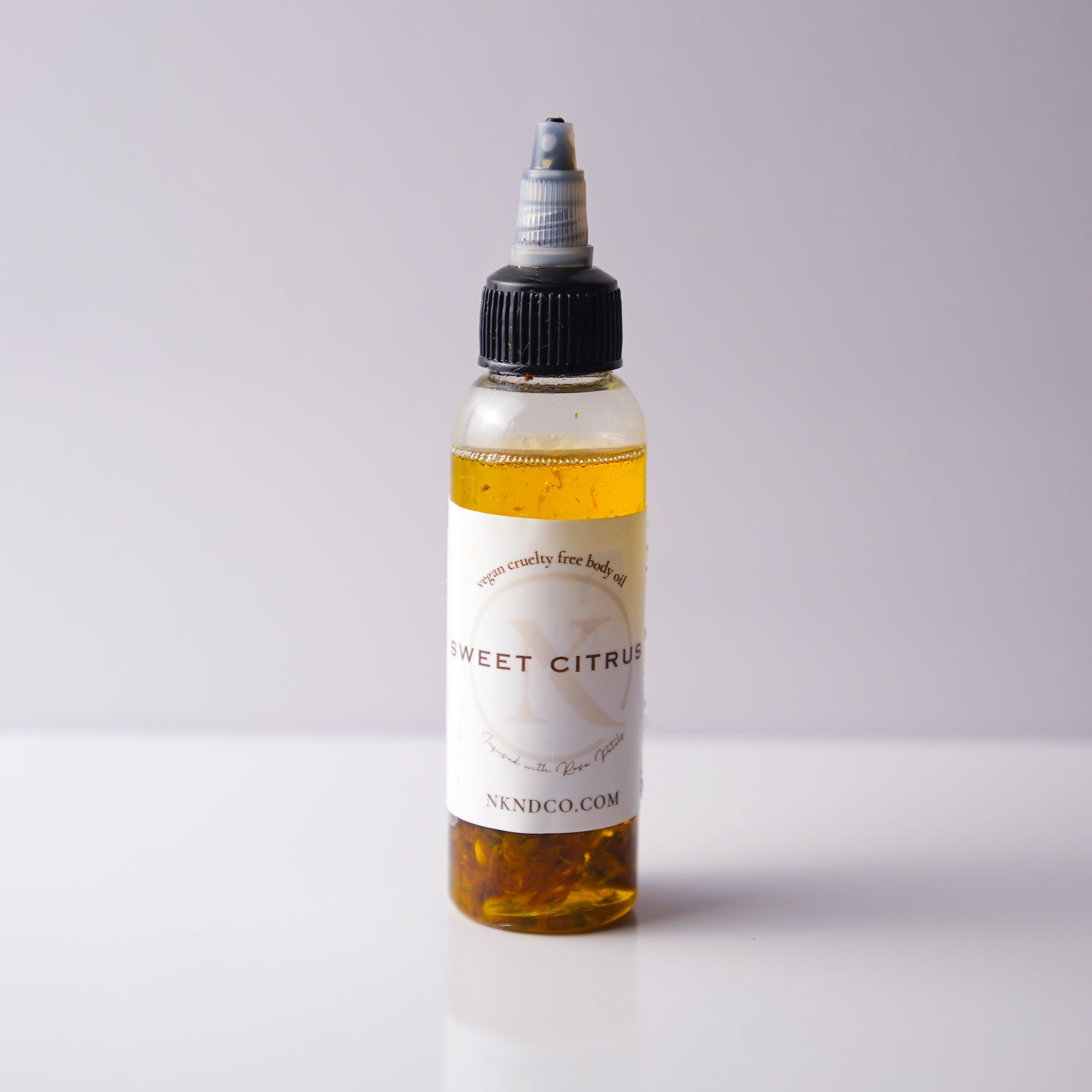 Bottle of 'Sweet Citrus' oil with a white label on a light gray background