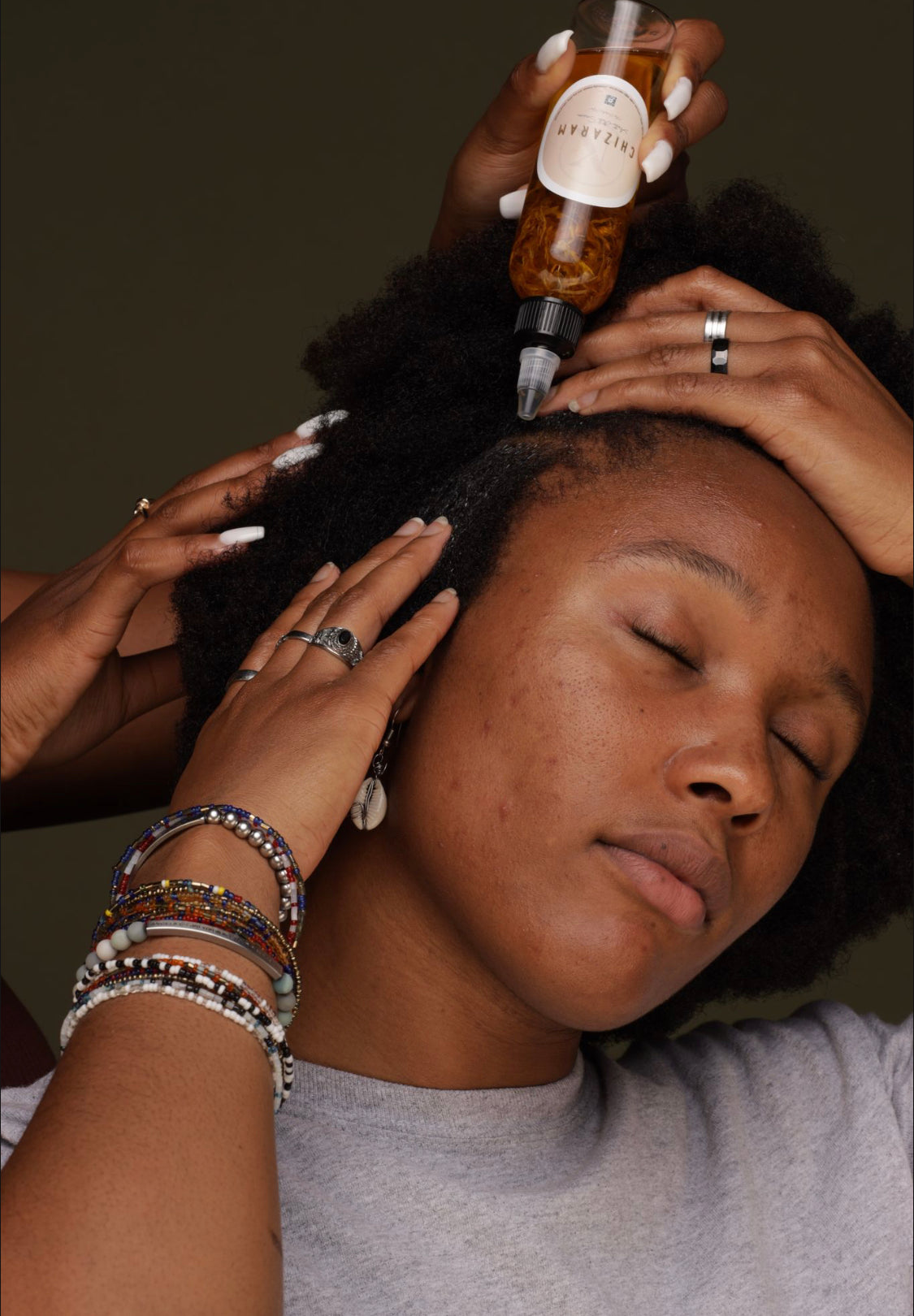 image of a woman having "Chizaram" Anti-Itch Serum applied to her hair