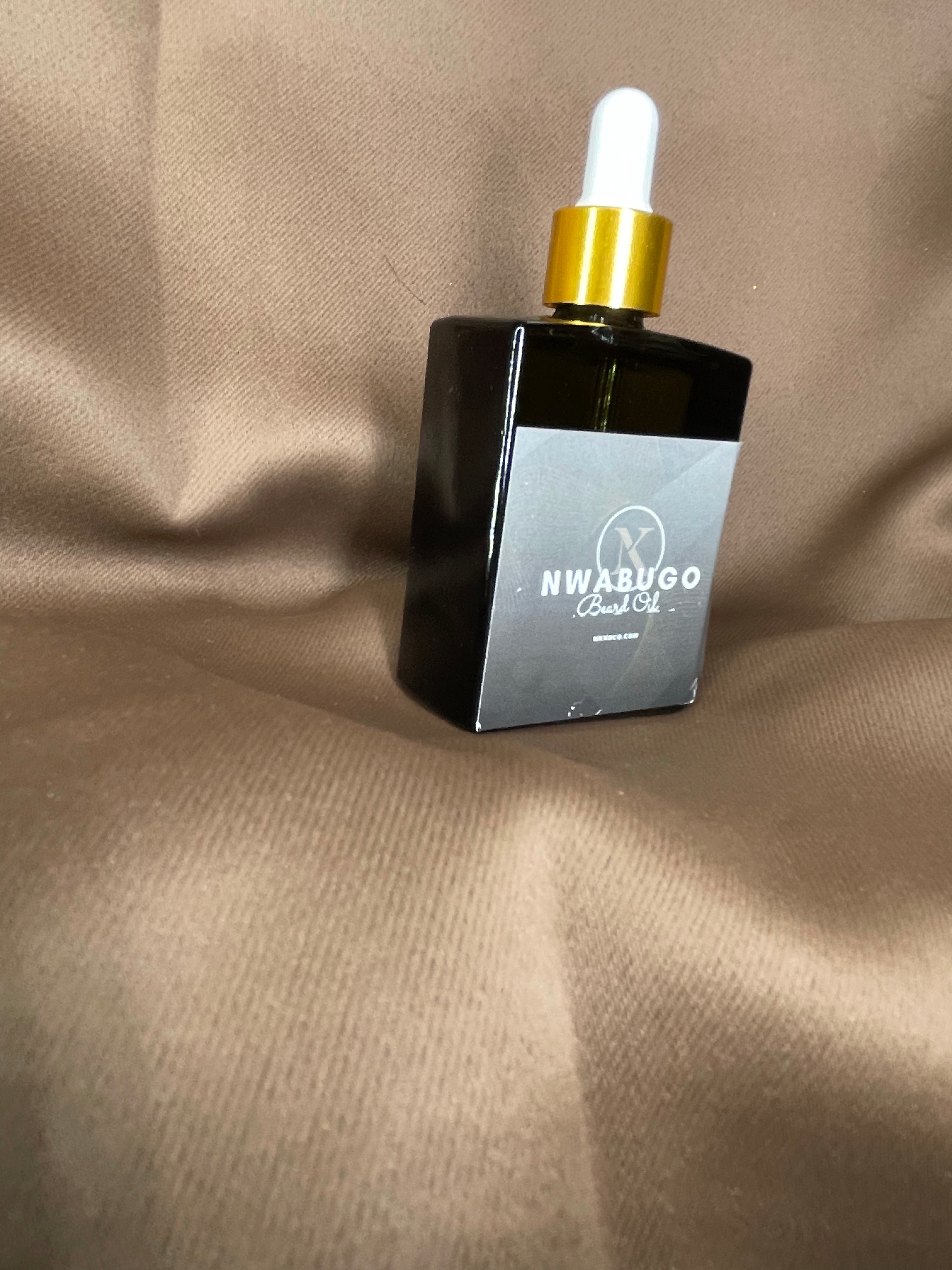 A bottle of Nwabugo beard oil with a dropper cap, displayed against a brown background.